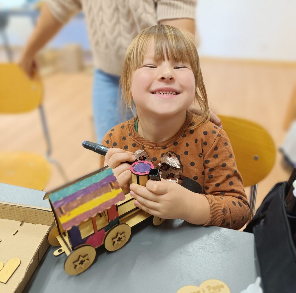 dziewczynka malująca włanoręcznie wykonany drewniany pociąg
